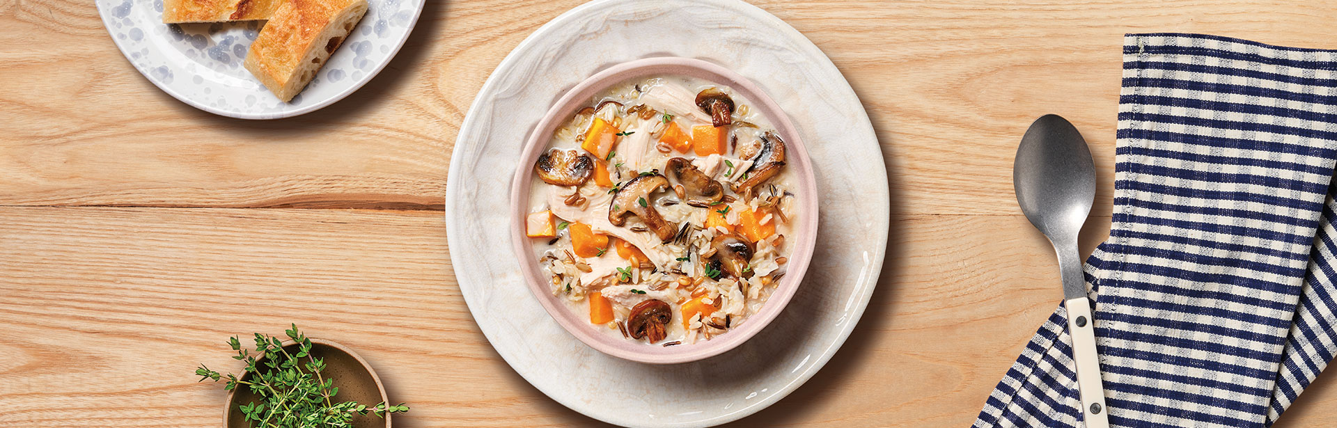 An image of prepared Autumn Wild Rice Chicken Soup showing a bowl of mushrooms, Swanson® Unsalted Chicken Broth, Campbell's® Condensed Cream of Mushroom Soup, sweet potatoes, chicken and long grain and wild rice.