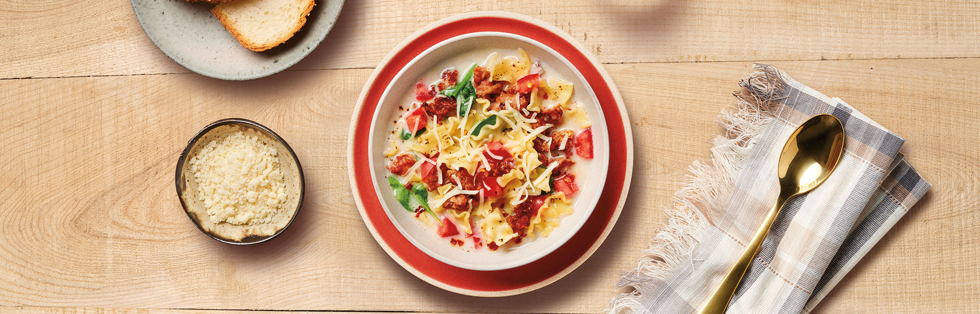 An image of prepared Creamy Spinach Lasagna Soup showing turkey sausage, Swanson® Unsalted Chicken Broth, Campbell's® Condensed Cream of Mushroom Soup, mini lasagna noodles (mafalda), baby spinach, Parmesan cheese and mozzarella cheese.