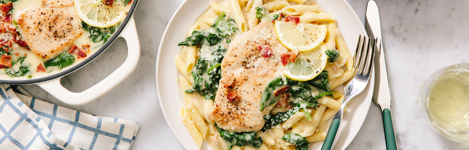 An image of prepared Creamy Garlic & Bacon Parmesan Chicken with Spinach showing chicken, bacon, baby spinach, Campbell's® Condensed Cream of Chicken Soup, Swanson® Unsalted Chicken Broth, Parmesan cheese and lemon juice.