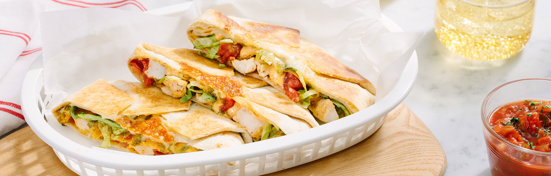 An image of prepared Crunchy Cheesy Chicken Taco Pockets showing chicken, Campbell's® Healthy Request® Condensed Cheddar Cheese Soup, sour cream, shredded lettuce, Pace® Picante Sauce Monterey Jack cheese and a corn tostada wrapped in a burrito-sized flour tortilla.